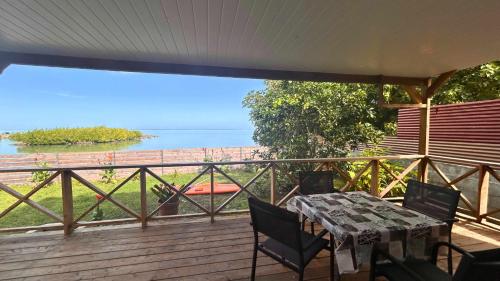 a table and chairs on a deck with a view of the ocean at MOOREA - Bungalow Nauhei Surf Spot 1 in Haapiti