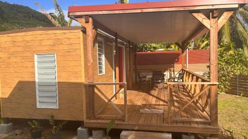 a tiny house with a porch and a roof at MOOREA - Bungalow Nauhei Surf Spot 2 in Haapiti
