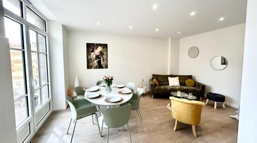 un salon avec une table, des chaises et un canapé dans l'établissement TI NEVEZ - Elégante Maison en Granit Ploumanach, à Perros-Guirec