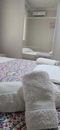 a bedroom with a bed with towels on it at The Hideaway Guesthouse in Bahçallëk