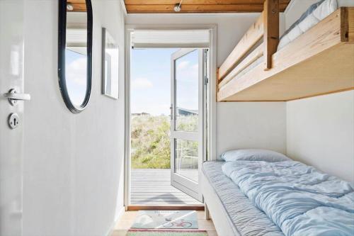 een bed in een kamer met een groot raam bij 235-Ringkobing-Vestklitvej-11 in Klegod