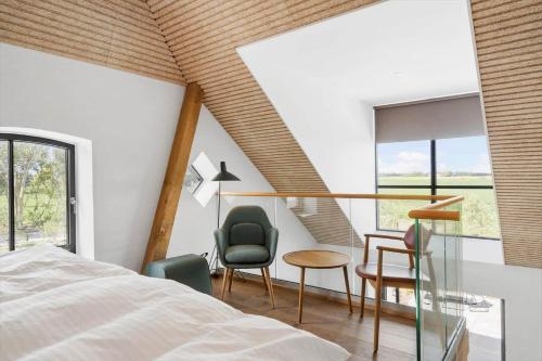 a bedroom with a bed and a table and chairs at 1170-Ringkobing-Jagtvej-34-C-lejl-1 in Ringkøbing