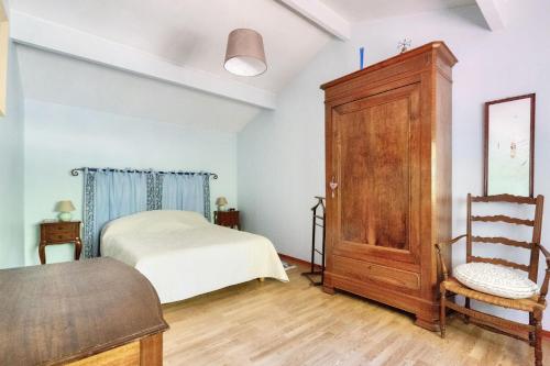 a bedroom with a bed and a wooden cabinet at Maison de campagne - maeva home - Maison 4 pièces 6 personnes - Confort MAE-7261 in Carcans