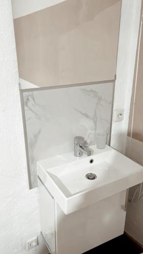a white bathroom with a sink and a mirror at Haus Leipheim in Leipheim