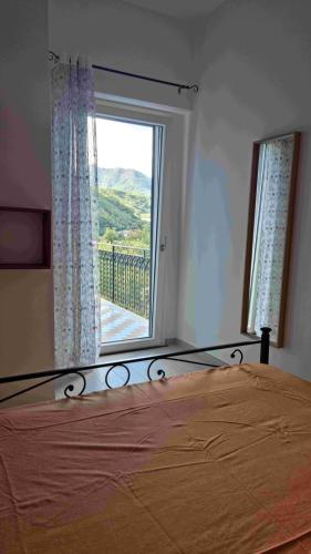 a bedroom with a bed and a large window at CASA VACANZE - Anna Holiday Home in Tramonti