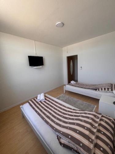 a room with two beds and a flat screen tv at Rooms ALEA in Sanski most
