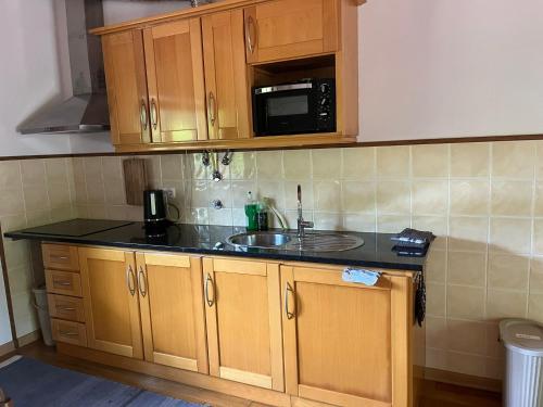 a kitchen with a sink and a microwave at Quinta dos Lagares 