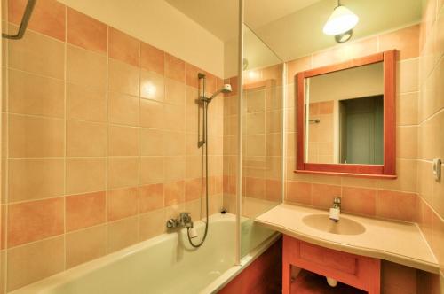 ein Badezimmer mit Waschbecken, Badewanne und Spiegel in der Unterkunft La résidence du Lac - maeva Home - Appartement 2 pièces 4 personnes - Sélection MAE-0263 in Monflanquin
