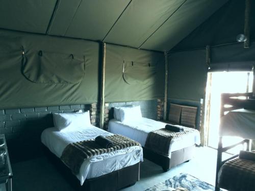 a room with two beds in a tent at Carlo's Mountain Lodge in Usakos