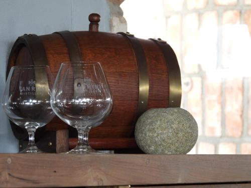 two wine glasses sitting on top of a wooden barrel at Carlo's Mountain Lodge in Usakos
