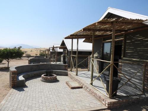 a building with a fire pit in front of it at Carlo's Mountain Lodge in Usakos