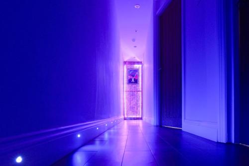 a hallway with a door in a room with purple lights at Hyacinth Apartments - Hot Tub Garden Escape - Adults only in Brighton & Hove