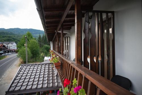 a balcony of a house with flowers on it at Pensiunea Adonis in Arefu