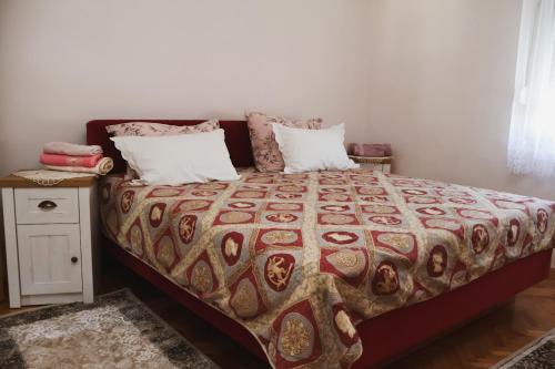a bedroom with a bed and a night stand at Apartman ODISEJ in Čapljina