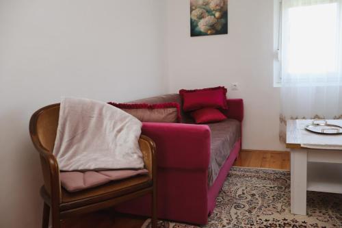 a couch and a chair in a living room at Apartman ODISEJ in Čapljina