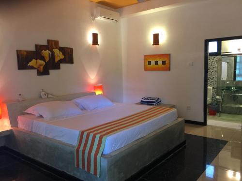 a bedroom with a large bed in a room at Flower Garden Eco Village in Sigiriya