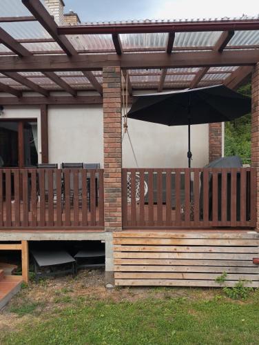 a wooden pergola with an umbrella on a deck at Dovolenkovy dom s terasou in Spišská Nová Ves