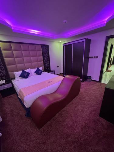 a large bedroom with a large bed with purple lighting at شقق شيل دون للشقق المخدومة in Muhayil
