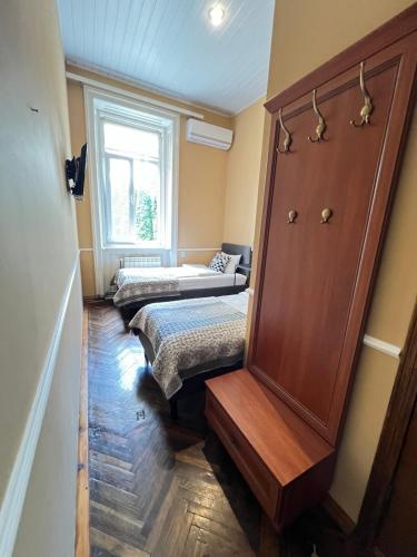 a room with two beds and a dresser and a window at Kavaler inn hotel in Kuty
