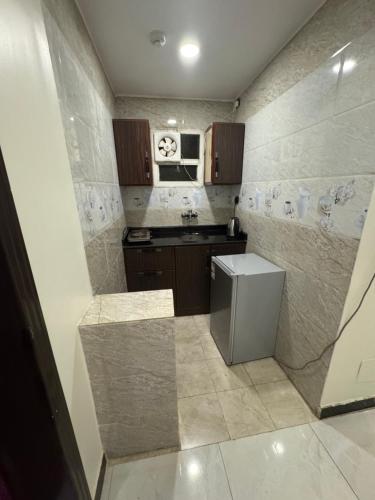 a small kitchen with a sink and a refrigerator at شقق شيل دون للشقق المخدومة in Muhayil