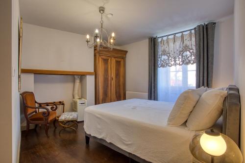 Maison 3 pièces , terrasse LA BOUQUERIE في سارلا لا كانيدا: غرفة نوم بها سرير وكرسي ونافذة