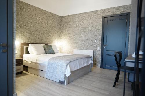 a bedroom with a bed and a blue door at Hotel Saguramo Bliss in Saguramo