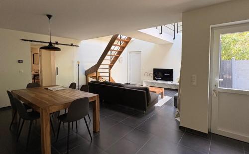 a dining room and living room with a table and chairs at Vakantiehuis Coconne in Waregem