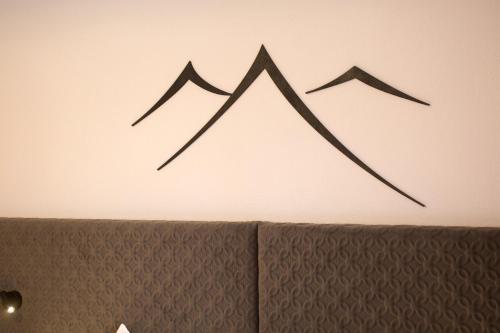 a painting of two mountains on a wall at Ferienhotel Bergland in Arzl im Pitztal