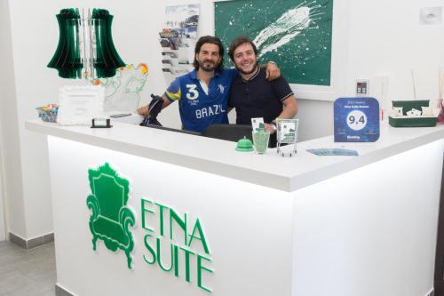 two men standing behind a counter in a store at Etna Suite Group in Catania