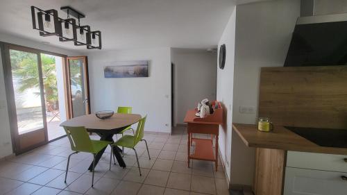 eine Küche und ein Esszimmer mit Tisch und Stühlen in der Unterkunft Maison Quartier du Phare in La Tranche-sur-Mer