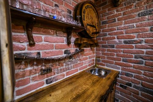 a brick wall with a clock and a wooden counter at Apartmani Petra i Tea in Krapina