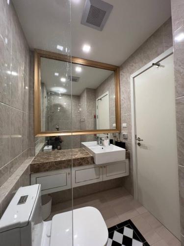 a bathroom with a toilet and a sink and a shower at The Empire Tower in Jomtien Beach