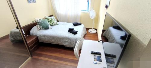 a small bedroom with a bed and a mirror at Castro-urdiales Apartamento 3 minutos de la playa in Castro-Urdiales