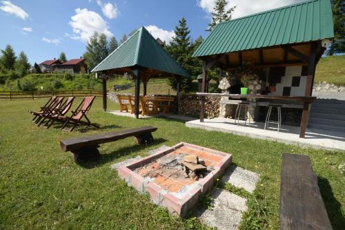 a picnic shelter with a table and benches in a field at Durmitor Bungalows in Žabljak
