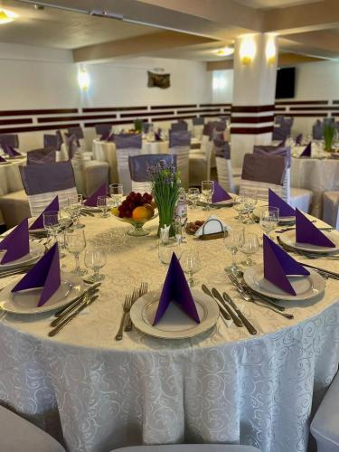 a table with purple napkins and silverware on it at Pensiunea Adonis in Arefu
