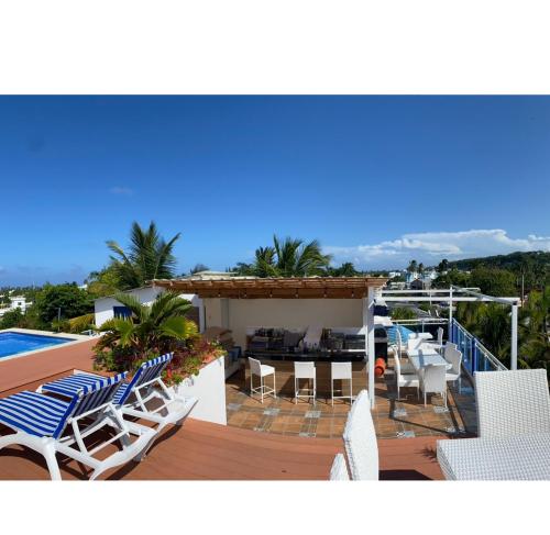 a deck with chairs and a table and a pool at Hotel Down Town Cabrera in Cabrera