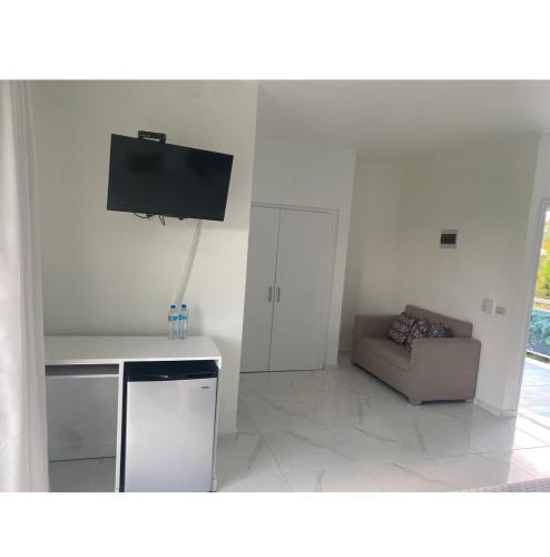 a living room with a couch and a flat screen tv at Hotel Down Town Cabrera in Cabrera
