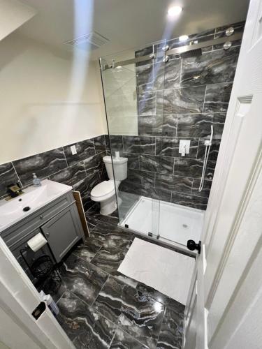 Un baño con ducha, inodoro y lavabo. en Your Comfortable Home Away From Home, en North Bergen