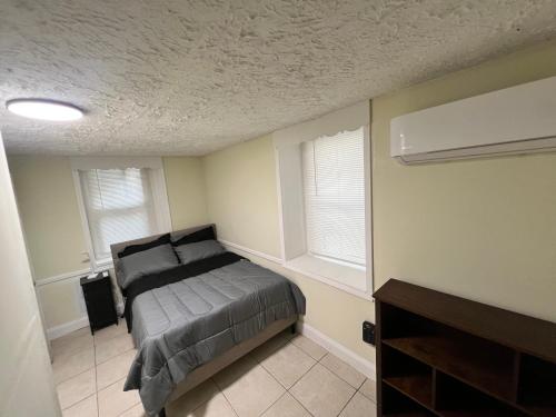 Un dormitorio con una cama y dos ventanas. en Your Comfortable Home Away From Home, en North Bergen