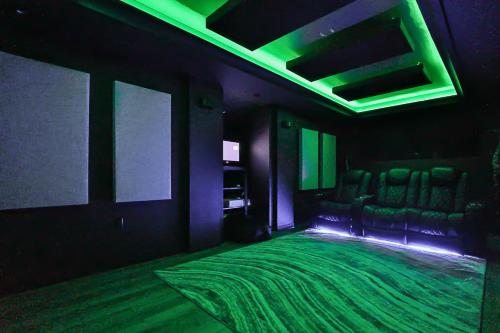 トロントにあるLuxurious Spa Retreat - Toronto Escapeの椅子のある部屋に緑色のベッドが置かれた暗い部屋