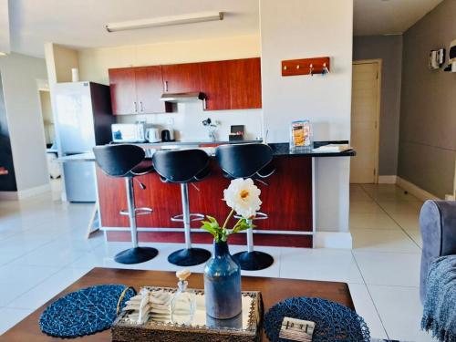 a kitchen with a table with a vase with a flower in it at Driftwood Dreams in Bay View