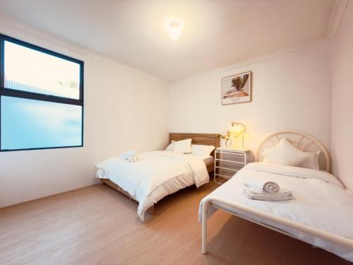 two beds in a room with a window at City Explorer Base 3BR&2 Floors&Walk to Mall & Airport Transit in Perth