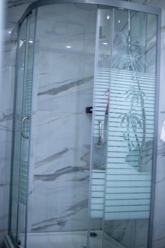 an elevator with a glass door with a plant on it at Reeq Residence Naguru Kampala in Nalakonge