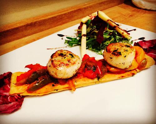 a plate of food with scallops on top at Hôtel Beau Soleil in Le Lavandou