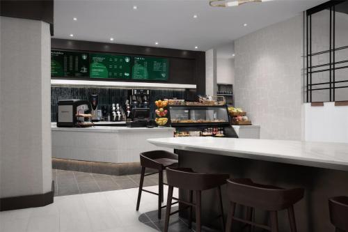a restaurant with a bar with stools and a counter at Hilton Arlington National Landing in Arlington