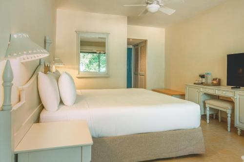 a bedroom with a white bed and a desk at Iberostar Waves Costa Dorada - All Inclusive in San Felipe de Puerto Plata