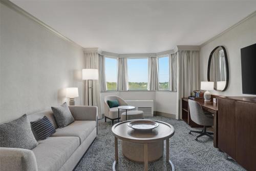 a living room with a couch and a table and a desk at Hilton Arlington National Landing in Arlington