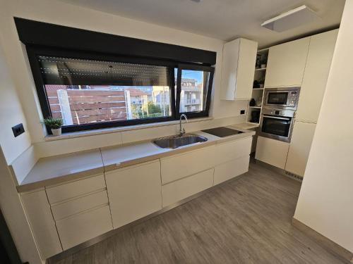 a large kitchen with a sink and a window at TheTomonina house with pool in Split