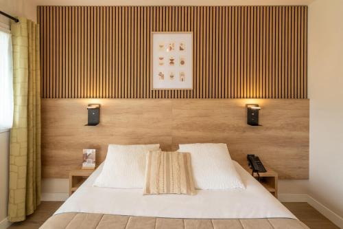 a bedroom with a bed with two lights on it at Sure Hotel by Best Western Mont-de-Marsan in Saint-Pierre-du-Mont