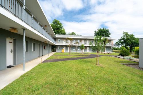 an exterior view of a building with a grass yard at Sure Hotel by Best Western Mont-de-Marsan in Saint-Pierre-du-Mont